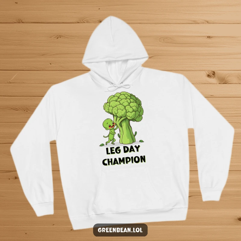 Funny hoodie depicting a tenacious green bean character scaling a giant broccoli, evoking humor and perseverance for cozy wear.