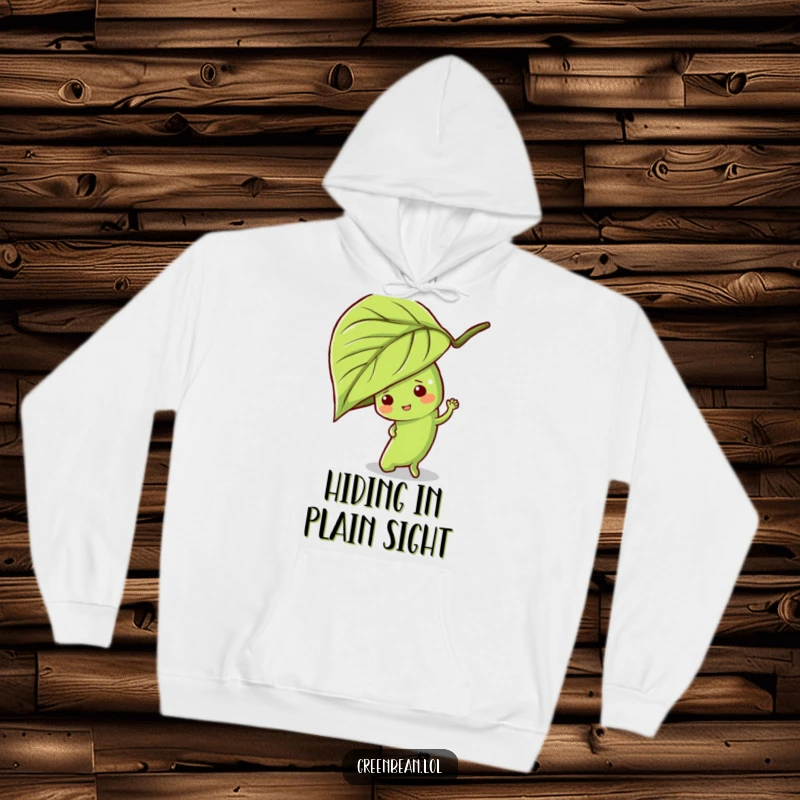 Funny green bean hoodie depicting a mischievous character playing hide-and-seek behind a leafy plant, ideal for cozy, playful wear.
